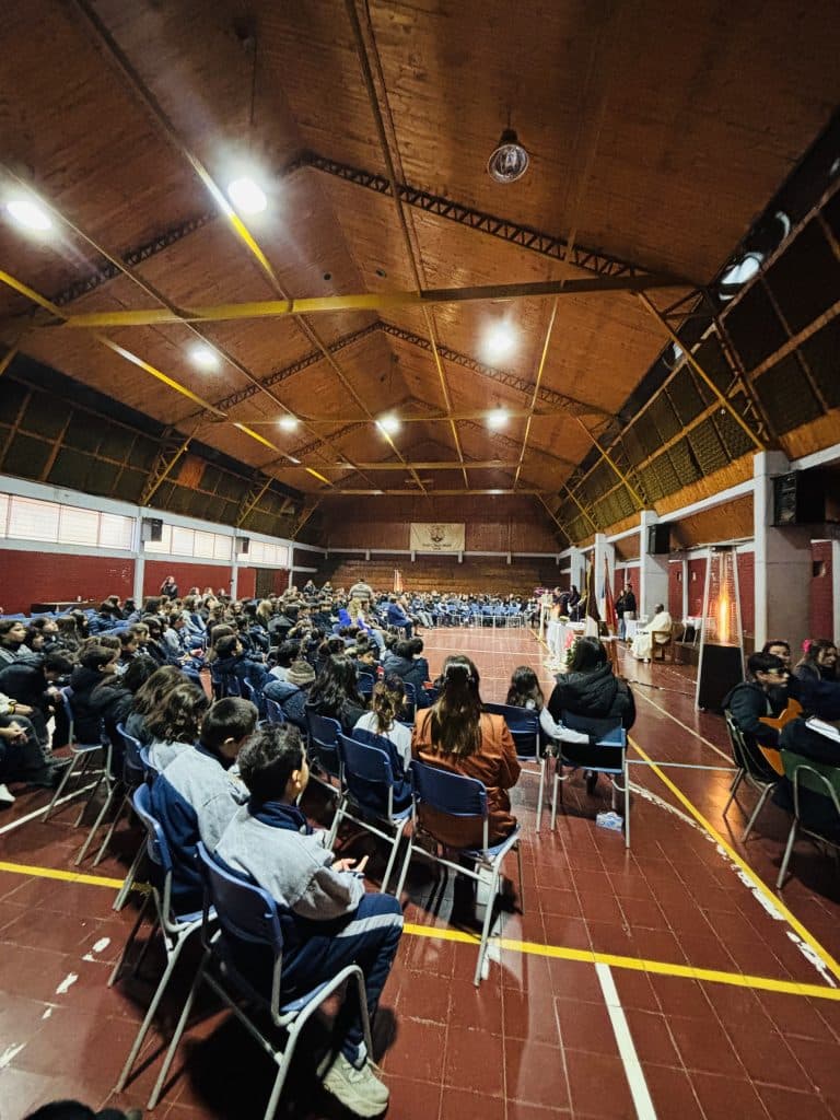 La comunidad escolar reunida en el gimnasio durante una celebración.