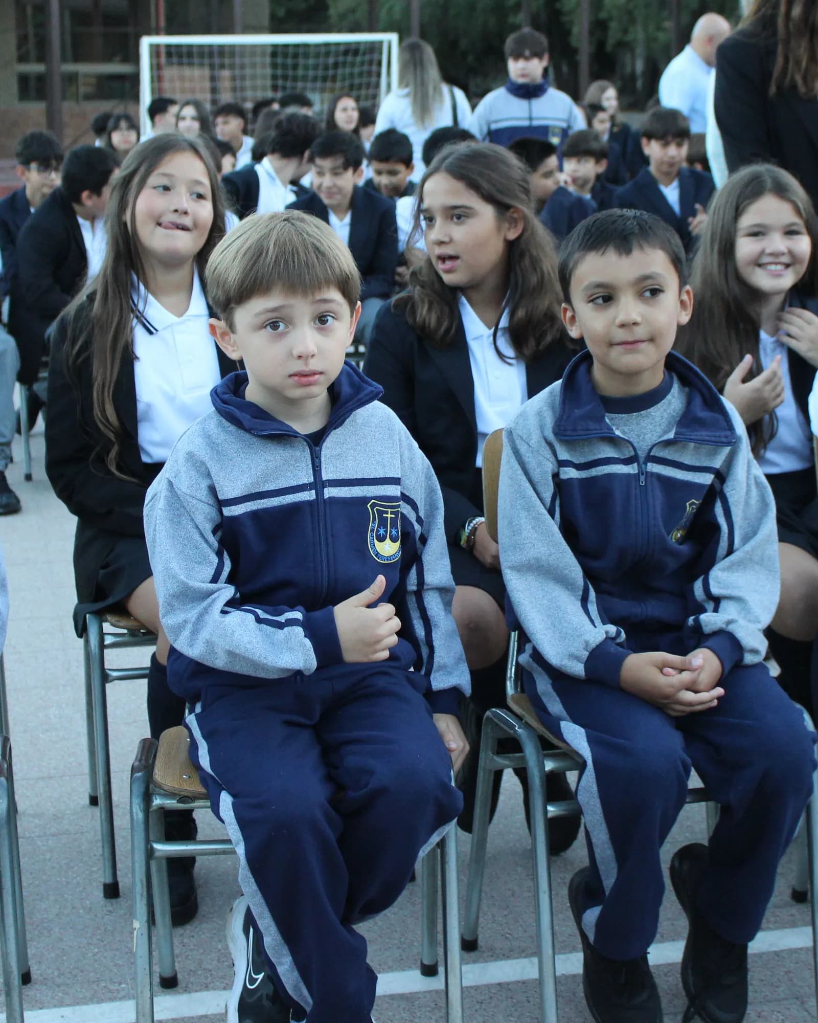 Estudiantes del ciclo menor con uniforme del colegio, sentados durante el acto de inicio del año escolar.