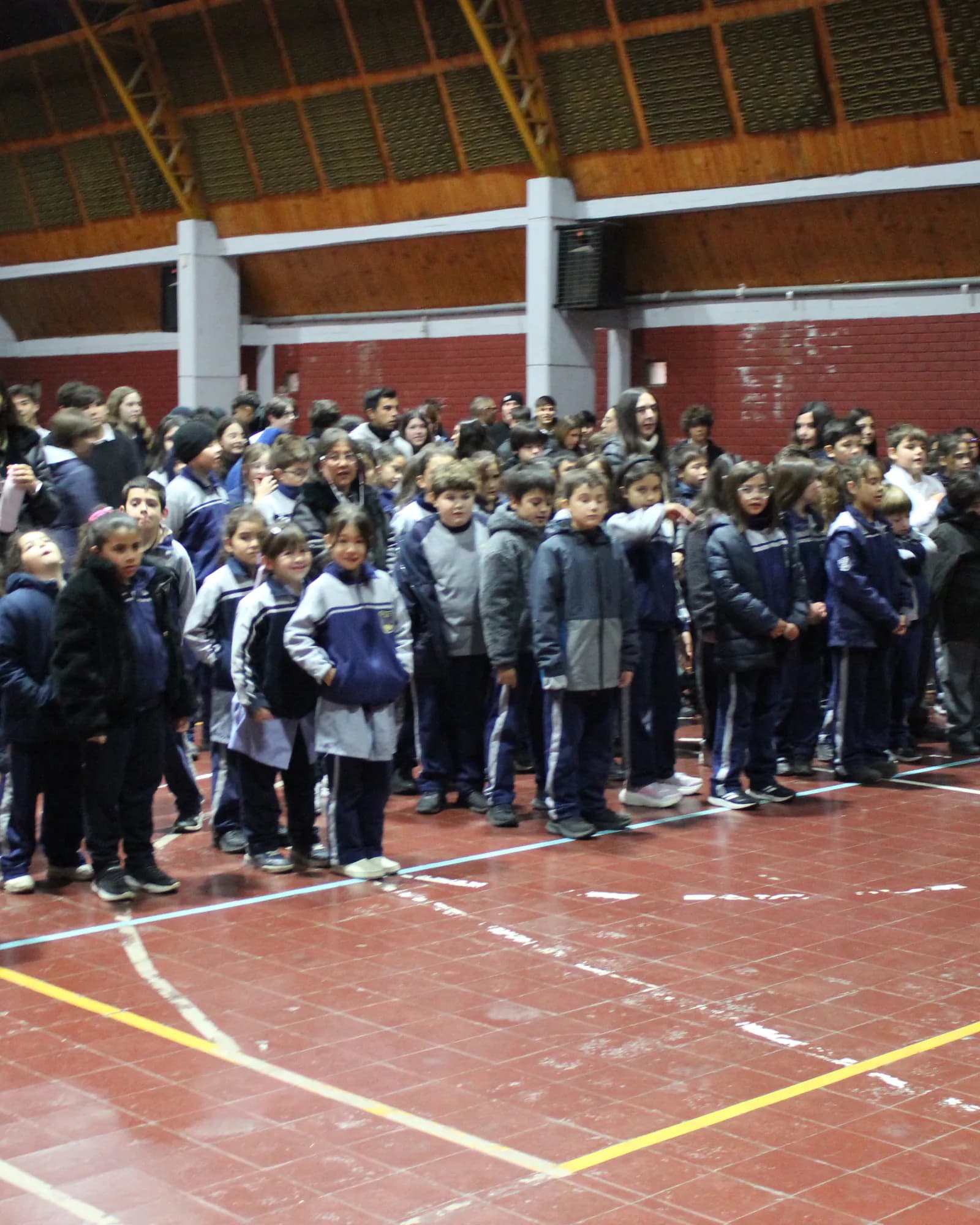 La comunidad escolar se reúne para una actividad en el gimnasio.