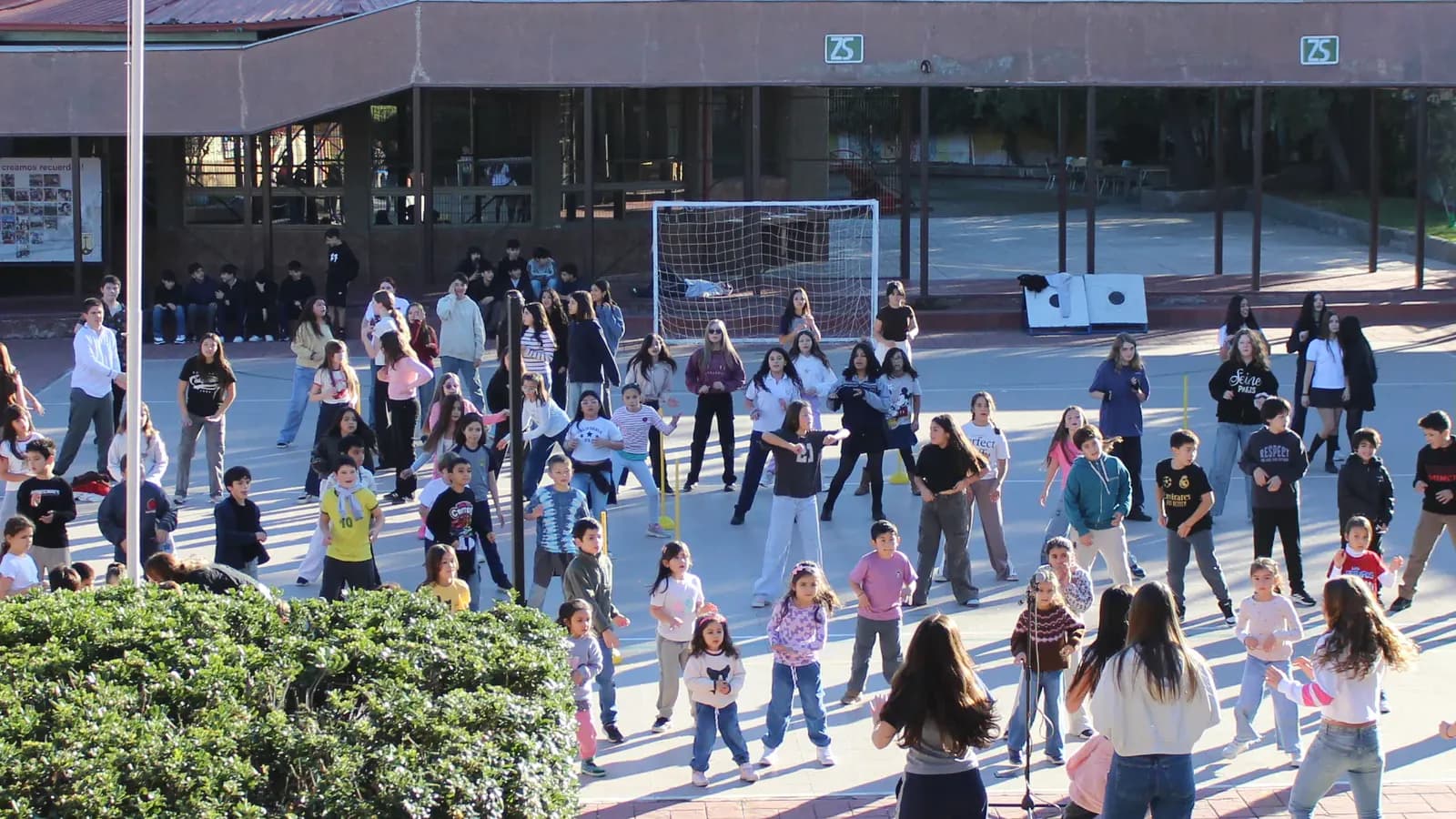 Estudiantes participan en una actividad comunitaria en el patio central del colegio.